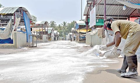 ஈரோட்டில் நேற்று முழு ஊரடங்கு காரணமாக வ.உ.சி.மைதானத்தில் செயல்படும் காய்கறிச்சந்தை செயல்படவில்லை. அங்கு கரோனா பரவலைத் தடுக்கும் வகையில் கிருமிநாசினி பவுடரை மாநகராட்சி பணியாளர்கள் தெளித்தனர்.