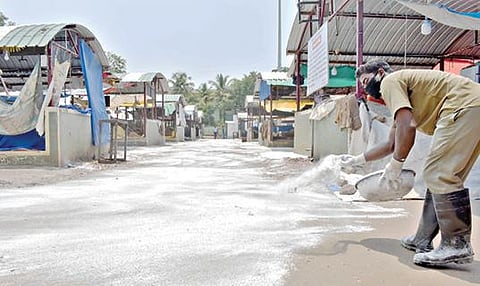 ஈரோட்டில் நேற்று முழு ஊரடங்கு காரணமாக வ.உ.சி.மைதானத்தில் செயல்படும் காய்கறிச்சந்தை செயல்படவில்லை. அங்கு கரோனா பரவலைத் தடுக்கும் வகையில் கிருமிநாசினி பவுடரை மாநகராட்சி பணியாளர்கள் தெளித்தனர்.