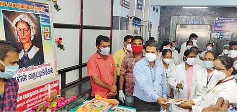 திண்டுக்கல்லில் நடந்த செவிலியர் தினவிழாவில் செவிலியர்களுக்கு புத்தகங்கள் வழங்கிய மருத்துவர் சுரேஷ்பாபு.