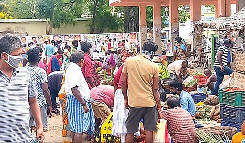 சிவகங்கை பேருந்துநிலையத்தில் தற்காலிக தினசரி சந்தையில் காய்கறிகள் வாங்க சமூக இடைவெளியின்றி குவிந்த மக்கள்.