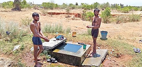 பரமத்தி அருகே சாலையோரத்தில் லாரியை நிறுத்தி கேட்வால்வில் கசியும் தண்ணீரில் ஆனந்த குளியல் போடும் லாரி ஓட்டுநர்கள். 	        படம்: கி. பார்த்திபன்