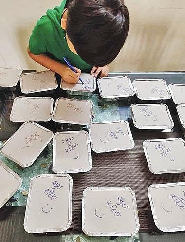 ஊரடங்கின் போது ஏழைகளுக்கு வழங்குவதற்கான உணவு பார்சல்களில் அன்பை பொழிந்த சிறுவன்: சமூக வலைதளங்களில் குவியும் பாராட்டு