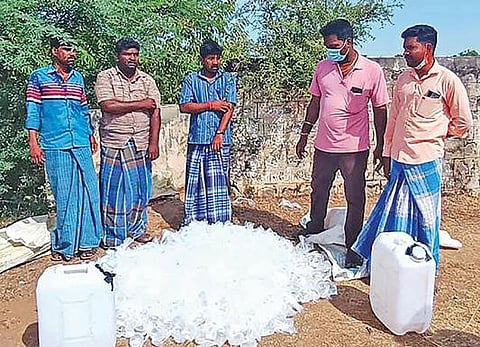செஞ்சி அருகே போலீஸாரால் பறிமுதல் செய்யப்பட்ட கள்ளச்சாராய பாக்கெட்டுகள் மற்றும் எரி சாராய கேன்கள்.