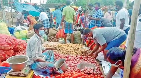 மகேந்திரா சிட்டி அருகே உள்ள சந்தையில் காய்கறி வாங்கும் மக்கள்.