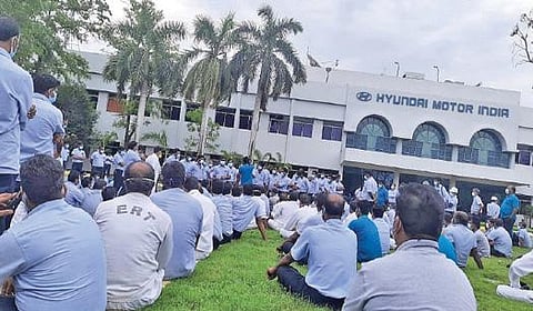 ஹூண்டாய் தொழிற்சாலை வாயிலில் அமர்ந்து போராட்டத்தில் ஈடுபட்ட தொழிலாளர்கள்.