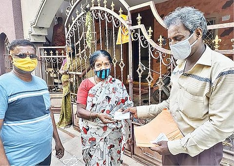 தமிழக அரசு அறிவித்த 14 வகையான ரேஷன் பொருட்கள் தொகுப்பை பெற, வேலூர் தோட்டப்பாளையம் புதுத்தெருவில் நேற்று வீடு, வீடாக சென்று டோக்கன் விநியோகம் செய்த நியாய விலைக்கடை ஊழியர். படம்: வி.எம்.மணிந்தன்.