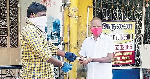 திருவண்ணாமலையில் 2-வது நாளாக நேற்று வீடு, வீடாக சென்று டோக்கன் வழங்கும் பணியில் ஈடுபட்ட நியாய விலை கடை ஊழியர்.