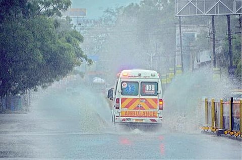 பாளையங்கோட்டை முருகன்குறிச்சியில் நேற்று மாலையில் பெய்த மழையால் சாலையில் தேங்கியிருந்த தண்ணீரை சிதறடித்து செல்லும் ஆம்புலன்ஸ். 					    படம்: மு. லெட்சுமி அருண்