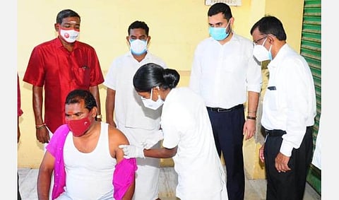 காரைக்கால்மேடு மீனவ கிராமத்தில் கரோனா தடுப்பூசி போடும் பணியைப் பார்வையிட்ட காரைக்கால் மாவட்ட ஆட்சியர் அர்ஜுன் சர்மா.