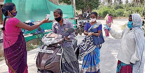 பட்டுக்கோட்டை அருகே உள்ள பள்ளிகொண்டானில் அமைக்கப்பட்டுள்ள சோத னைச் சாவடியில் உடல்நிலை குறித்து பரிசோதனை செய்யும் பணியாளர்கள்.