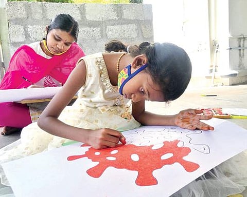 திருவண்ணாமலையில் கரோனா விழிப்புணர்வு ஓவியம் வரையும் மாணவிகள்.