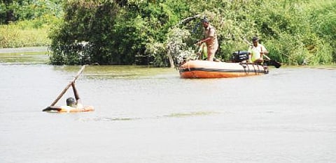 திருநெல்வேலி மீனாட்சிபுரம் அருகே தாமிரபரணி ஆற்றில் மூழ்கிய தந்தை மற்றும் மகனைத் தேடும் பணியில் தீயணைப்பு வீரர்கள் ஈடுபட்டனர். படம்: மு.லெட்சுமிஅருண்.