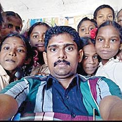 அரசுப் பள்ளி மாணவர்களுடன் ஆசிரியர் கார்த்திக் ராஜா.