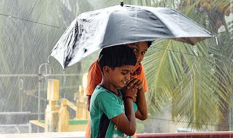 தூத்துக்குடியில் குடைபிடித்தபடி மழையை ரசித்த சிறுவர்கள். படம்: என்.ராஜேஷ்