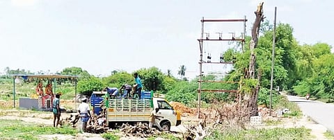 எலவனாசூர்கோட்டையில் மின்மாற்றி அமைப்பதற்காக வெட்டப்பட்ட மரங்களை ஏற்றிச் சென்ற வாகனத்தை பொதுமக்கள் மறித்ததால் அதே இடத்தில் மரங்களை இறக்கிவைக்கும் மர விற்பனையாளர்கள்.