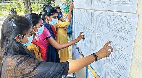 வேலூர் ஈவெரா நாகம்மை அரசு மகளிர் மேல்நிலைப் பள்ளி வளாகத்தில் ஓட்டப் பட்டிருந்த தேர்வு முடிவுகளை பார்வையிட்ட மாணவிகள்.  படம்: வி.எம்.மணிநாதன்.
