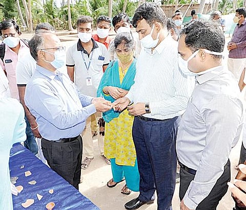 கீழடி அகழாய்வில் கண்டெடுக்கப்பட்ட தொல்பொருட்களை பார்வையிட்ட சுற்றுலா மற்றும் அறநிலையத் துறை முதன்மைச் செயலர் சந்திரமோகன். அருகில் சிவகங்கை மாவட்ட ஆட்சியர் பி.மதுசூதன்ரெட்டி.