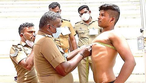 மதுரை ரேஸ்கோர்ஸ் மைதானத்தில் நடந்த உடற்தகுதித் தேர்வில் பங்கேற்ற இளைஞரின் மார்பை அளவீடு செய்த போலீஸார். படம்: எஸ்.கிருஷ்ணமூர்த்தி.