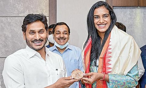 ஒலிம்பிக் பாட்மிண்டன் போட்டியில் வென்ற வெண்கலப் பதக்கத்தை ஆந்திர முதல்வர் ஜெகன்மோகன் ரெட்டியிடம் காண்பித்து மகிழும்  பி.வி.சிந்து. படம்: பிடிஐ