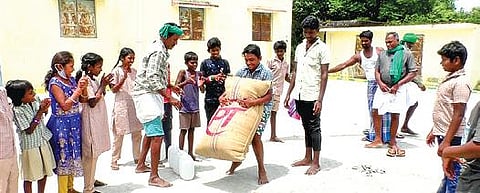 செய்யாறு அடுத்த வாழ்குடை கிராமத்தில் நடைபெற்ற நூதன விளையாட்டு போட்டியில் 75 கிலோ  நெல்மூட்டையை தூக்க முயன்ற இளைஞர்.