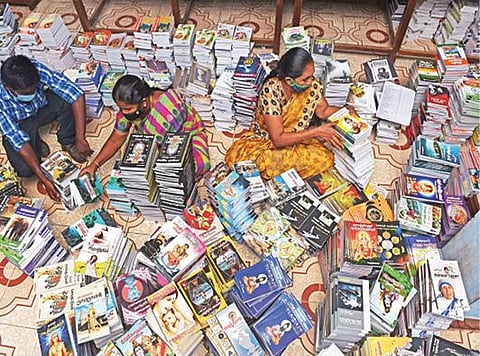 சேலம் மரவனேரியில் உள்ள மாவட்ட மைய நூலகத்தில் இருந்து புதிய புத்தகங்களை கிளை நூலகங்கள் மற்றும் ஊர்ப்புற நூலகங்களுக்கு பிரித்து அனுப்பும் பணியில் ஈடுபட்டுள்ள நூலகப் பணியாளர்கள்.  	                     படம்: எஸ்.குரு பிரசாத்