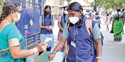 திருப்பூர் ஜெய்வாபாய் மாநகராட்சி பெண்கள் மேல்நிலைப்பள்ளிக்கு வந்த மாணவி களின் உடல் வெப்பநிலையை பரிசோதித்த ஆசிரியர்.