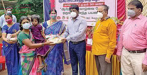 பெண் பயனாளி ஒருவருக்கு இரும்பு சத்து, புரதச் சத்து நிறைந்த பெட்டகத்தை ஆட்சியர் மோகன்  வழங்குகிறார்.