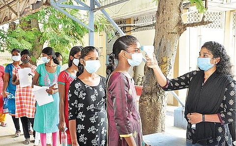 வேலூர் டிகேஎம் மகளிர் கல்லூரியில் நேற்று ‘நீட்’ தேர்வு எழுத வந்த மாணவிகளின் உடல் வெப்ப பரிசோதனை செய்யப்பட்டது. அடுத்த படம்: வேலூர் சாயிநாதபுரம் கிருஷ்ணசாமி மேல்நிலை பள்ளி தேர்வு மையத்துக்குள் செல்ல வரிசையில் காத்திருந்த மாணவிகள்.