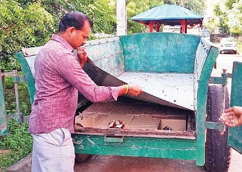 டிராக்டர் டிப்பரில் உள்அறை அமைத்து மதுபாட்டில் கடத்திவரப்பட்டதை காண்பிக்கும் போலீஸார்.