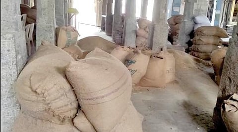 புளியங்குடி அருகே சிந்தாமணியில் உள்ள சொக்கலிங்க சுவாமி கோயில் வளாகத்தில் தேங்கிக் கிடக்கும் நெல் மூட்டைகள்.