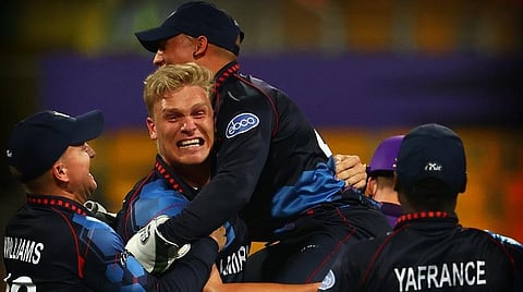 ஸ்காட்லாந்துக்கு எதிரான ஆட்டத்தில் முதல் ஓவரிலேயே 3 விக்கெட்டுகளை வீழ்த்திய ட்ரம்ப்பிள்மேனை பாராட்டிய நமிபியா வீரர்கள் | படம் உதவி ட்விட்டர்