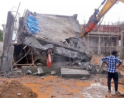 திருப்பூர் சின்னாண்டிபாளையத்தில் -  ஒன்றரை அடி ஆழத்துக்கு மண்ணில் புதைந்த அரசு கட்டிடம்  :  இடித்து அகற்றும் பணி உடனடியாக தொடக்கம்