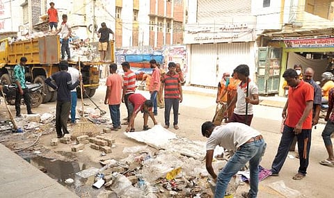 மதுரை விளக்குத்தூண் பகுதியில் தூய்மைப் பணியாளர்களுடன் குப்பைகளை அகற்றும்  ஜனநாயக வாலிபர் சங்கத்தினர். படம்: எஸ்.கிருஷ்ணமூர்த்தி