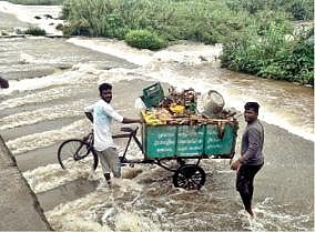 மாதனூர் பாலாறு தரைப்பாலத்தில் இருந்தபடி வீடுகளில் சேகரிக்கப்பட்ட குப்பையை கொட்டும் தூய்மை பணியாளர்கள்.