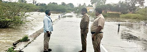 மகேந்திரவாடி ஏரி நிரம்பியதால் அங்கு பாதுகாப்பு பணியில் ஈடுபட்டுள்ள காவலர்கள்.