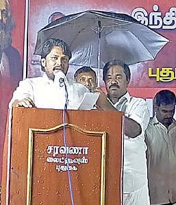 புதுக்கோட்டையில் பொதுக்கூட்ட மேடையில் பேசும் தொண்டர் மழை யில் நனையாமல் இருக்க, அவருக்கு குடைபிடித்தபடி நிற்கிறார்  எம்எல்ஏ எம்.சின்னதுரை.