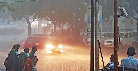 பாளையங்கோட்டையில் நேற்று மாலையில் கனமழையின்போது முகப்பு விளக்கை எரியவிட்டு தண்ணீரில் மிதந்தபடி சென்ற கார். (வலது) திருநெல்வேலி பெருமாள்புரத்தில் தற்காலிகமாக அமைக்கப்பட்டுள்ள புதிய பேருந்து நிலையம் நேற்று மாலை பெய்த கனமழையால் குளமாக மாறியது. அங்கிருந்து தண்ணீரை வெளியேற்றும் பணியில் மாநகராட்சி ஊழியர்கள் ஈடுபட்டனர்.படங்கள்: மு. லெட்சுமி அருண்