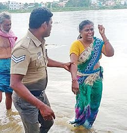 வைகை ஆற்றில் இறங்கி தற்கொலைக்கு முயன்ற மல்லிகாவை காப்பாற்றி அழைத்து வந்த காவலர் பாலமுருகன்.