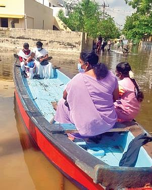 தூத்துக்குடி ரஹ்மத் நகர் பகுதியில் படகில் சென்று வீடு, வீடாக மருந்து விநியோகம் செய்த சுகாதாரப் பணியாளர்கள்.