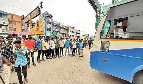 திருவண்ணாமலை மத்திய பேருந்து நிலைய நுழைவு வாயில் முன்பு பேருந்துகளை வெளியே செல்லவிடாமல் மறித்து நேற்று போராட்டத்தில் ஈடுபட்ட கல்லூரி மாணவர்கள். படம்: இரா.தினேஷ்குமார்.