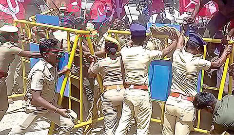 சிங்கம்புணரியில் தனியார் ஆலை முற்றுகை போராட்டத்தின்போது தடுப்புகளை தாண்டி வந்த தொழிலாளர்களை தடுத்து நிறுத்திய போலீஸார்.