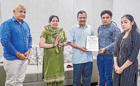 டெல்லி கலவரத்தில் உயிரிழந்த அங்கித் ஷர்மாவின் தம்பி அன்குர் ஷர்மாவுக்கு பணி நியமன ஆணையை டெல்லி முதல்வர் அர்விந்த் கேஜ்ரிவால் நேற்று வழங்கினார்.படம்: பிடிஐ