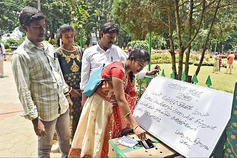 ஏற்காட்டில், கோடை விழாவுக்கான ஏற்பாடுகள் நடைபெற்று வரும் நிலையில், மலர்க்கண்காட்சிக்காக அண்ணா பூங்காவில் பிரம்மாண்ட மலர்ச் சிற்பம் அமைக்கப்பட உள்ளது. இதற்காக, பூங்கா நுழைவு வாயிலில் வைக்கப்பட்டுள்ள பெட்டியில்,  தங்கள் கருத்துகளை எழுதி போட்டு வரும்  சுற்றுலாப் பயணிகள். 			   படம்: எஸ்.குரு பிரசாத்