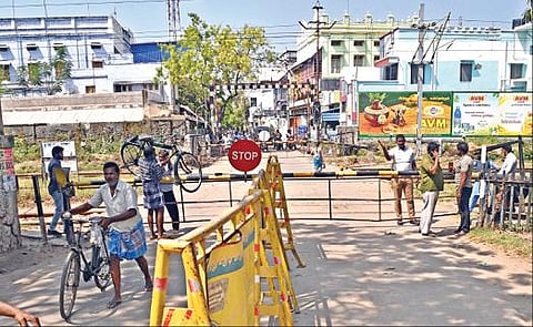 தூத்துக்குடி 1-வது ரயில்வே கேட் நீண்ட நேரமாக பூட்டப்பட்டிருந்ததால் சைக்கிள்களை  தூக்கிக் கொண்டு  கேட்டை தாண்டிச்  சென்ற மக்கள். படம்: என்.ராஜேஷ்