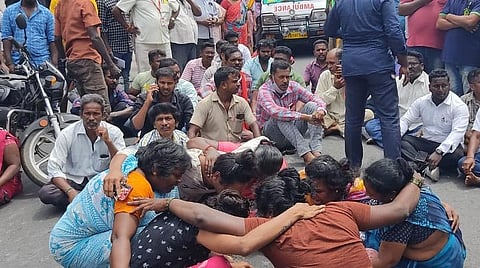 குழந்தை இறந்ததால் சாலையில் அமர்ந்து கண்ணீர் விடும் அவரது குடும்பத்தினர்.