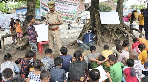 உத்தரபிரதேச மாநிலம் அயோத்தியில் ஏழை சிறுவர்களுக்கு சீருடையில் பாடம் கற்பிக்கிறார் காவல் துணை ஆய்வாளர் ரஞ்சீத் யாதவ். படம்: பிடிஐ