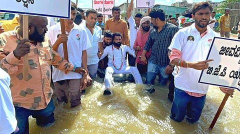 வெள்ள பாதிப்புகளை சீர் செய்யாத கர்நாடகா அரசை கண்டித்து அம்மாநில இளைஞர் காங்கிரஸ் கமிட்டி தலைவர் டியூபில் மிதந்து போராட்டம் நடத்தினார்.