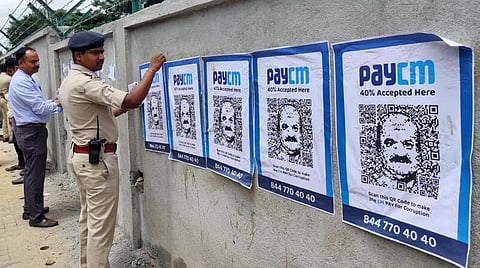 பெங்களூருவில் முதல்வர் பசவராஜ் பொம்மை படத்துடன் ஒட்டப்பட்டுள்ள ‘பே சிஎம்’  போஸ்டர்.