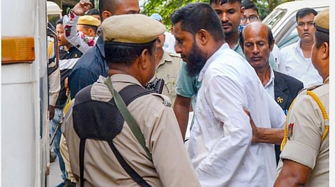 அசாம் மாநிலம் குவாஹாட்டியில் மாநில போலீஸாருடன் இணைந்து என்ஐஏ அதிகாரிகள் நேற்று சோதனை நடத்தினர். அப்போது ஒரு பிஎஃப்ஐ நிர்வாகியை விசாரணைக்காக அழைத்துச் செல்கின்றனர்.படம்: பிடிஐ