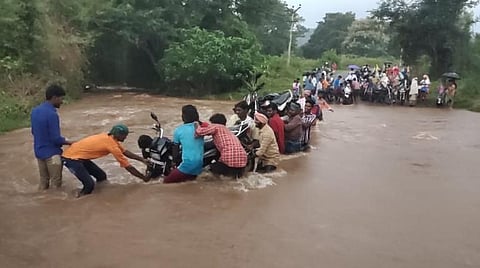கல்வராயன் மலையில் பெய்த மழையில் மூழ்கிய தரைப்பாலத்தை கடந்து செல்லும்  மக்கள்